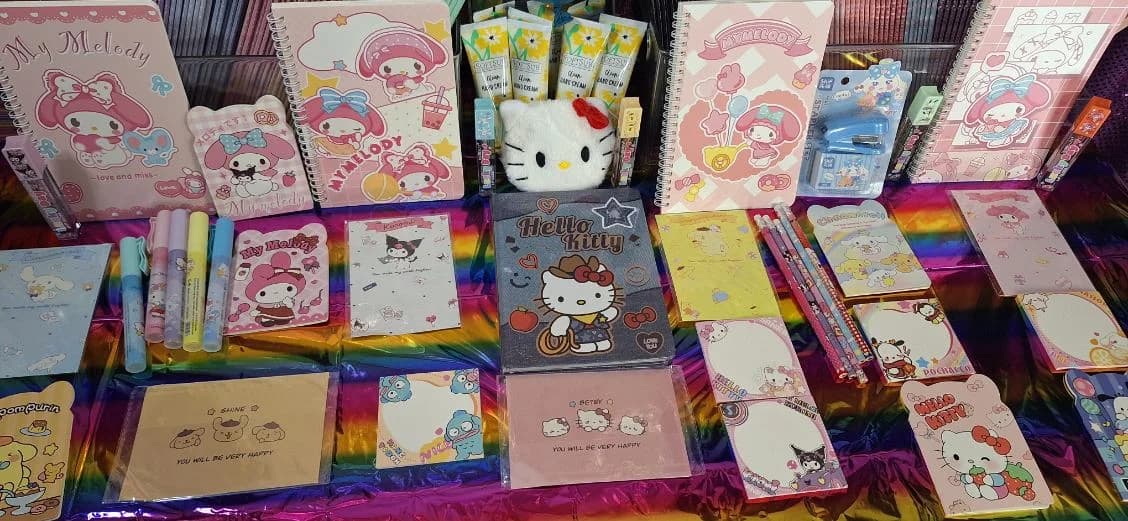 Colorful notepads, notebooks, pencils, and small stationery items on a prize table
